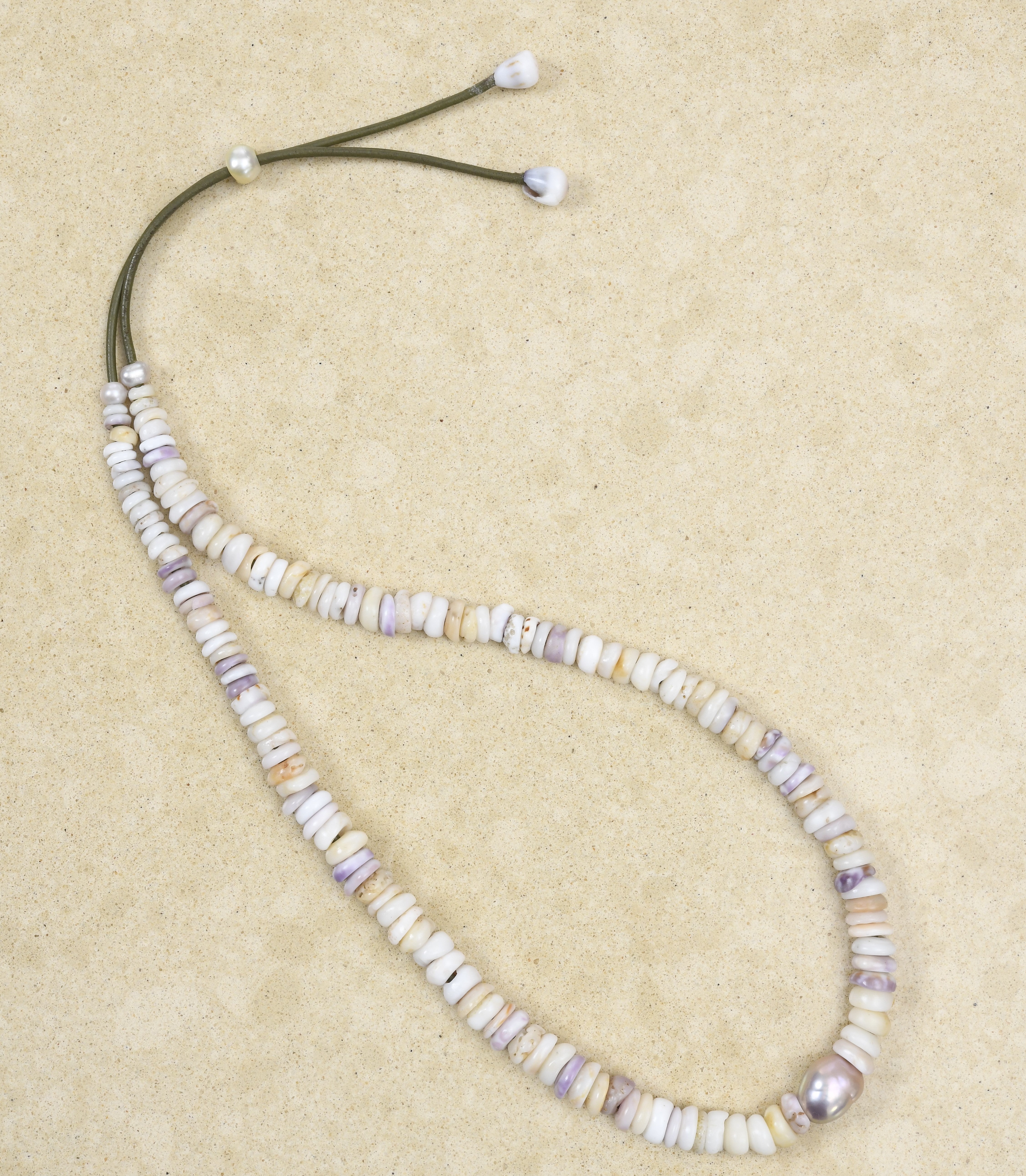 Puka lei with pink Edison pearl on green leather adjustable cord