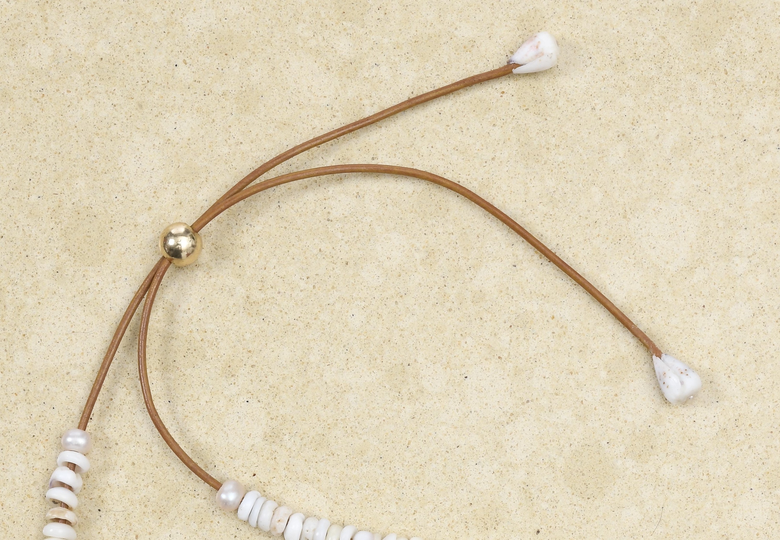 Pu·ka /ˈpo͞okə lei on adjustable brown leather cord