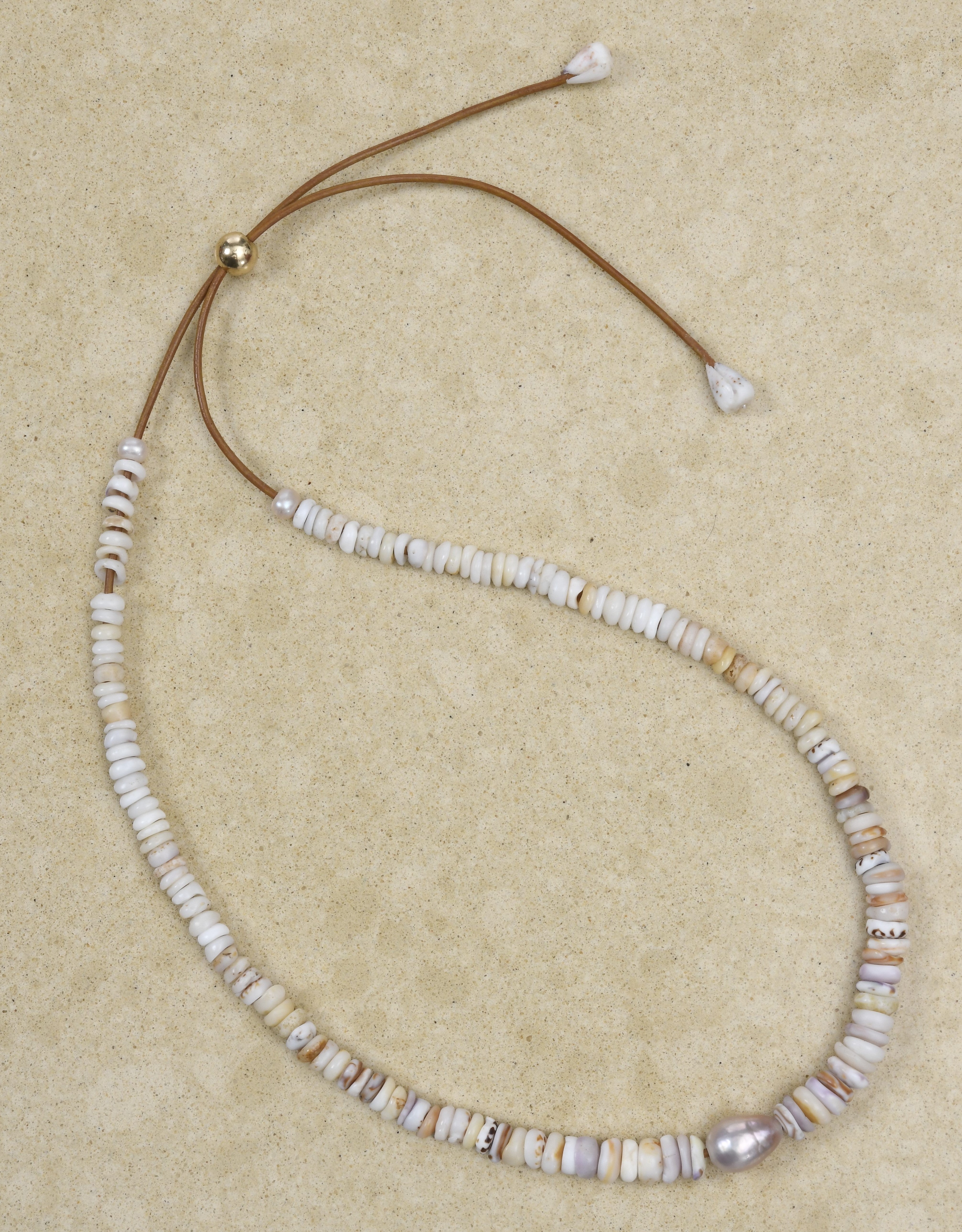 Pu·ka /ˈpo͞okə lei on adjustable brown leather cord