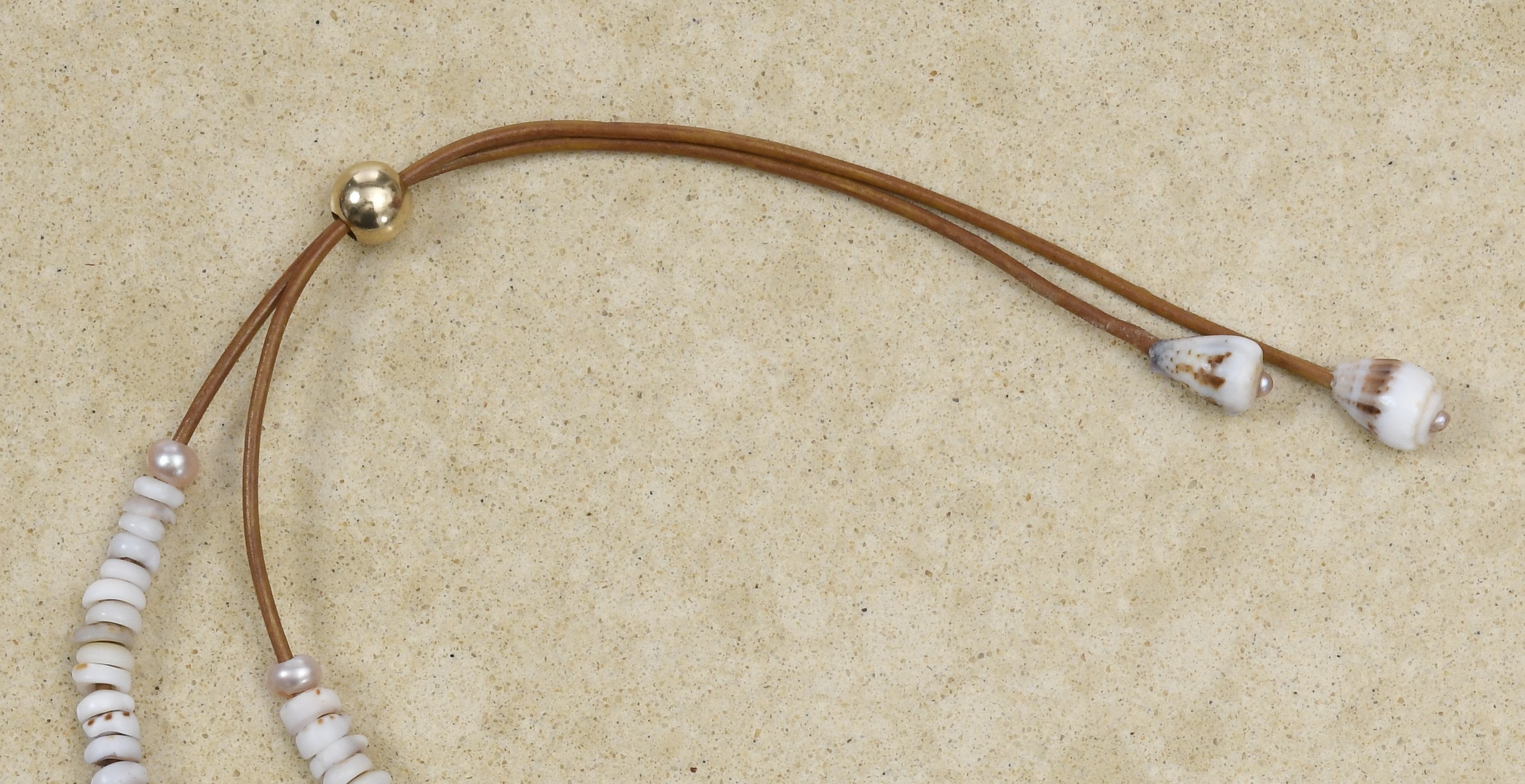 Puka lei with pearls on brown leather cord adjustable